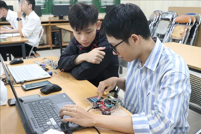 Sinh viên miệt mài tương tác, tranh luận và cùng nhau lập trình phần cứng trên máy tính tại phòng lab. (Ảnh: Xuân Quý/TTXVN)